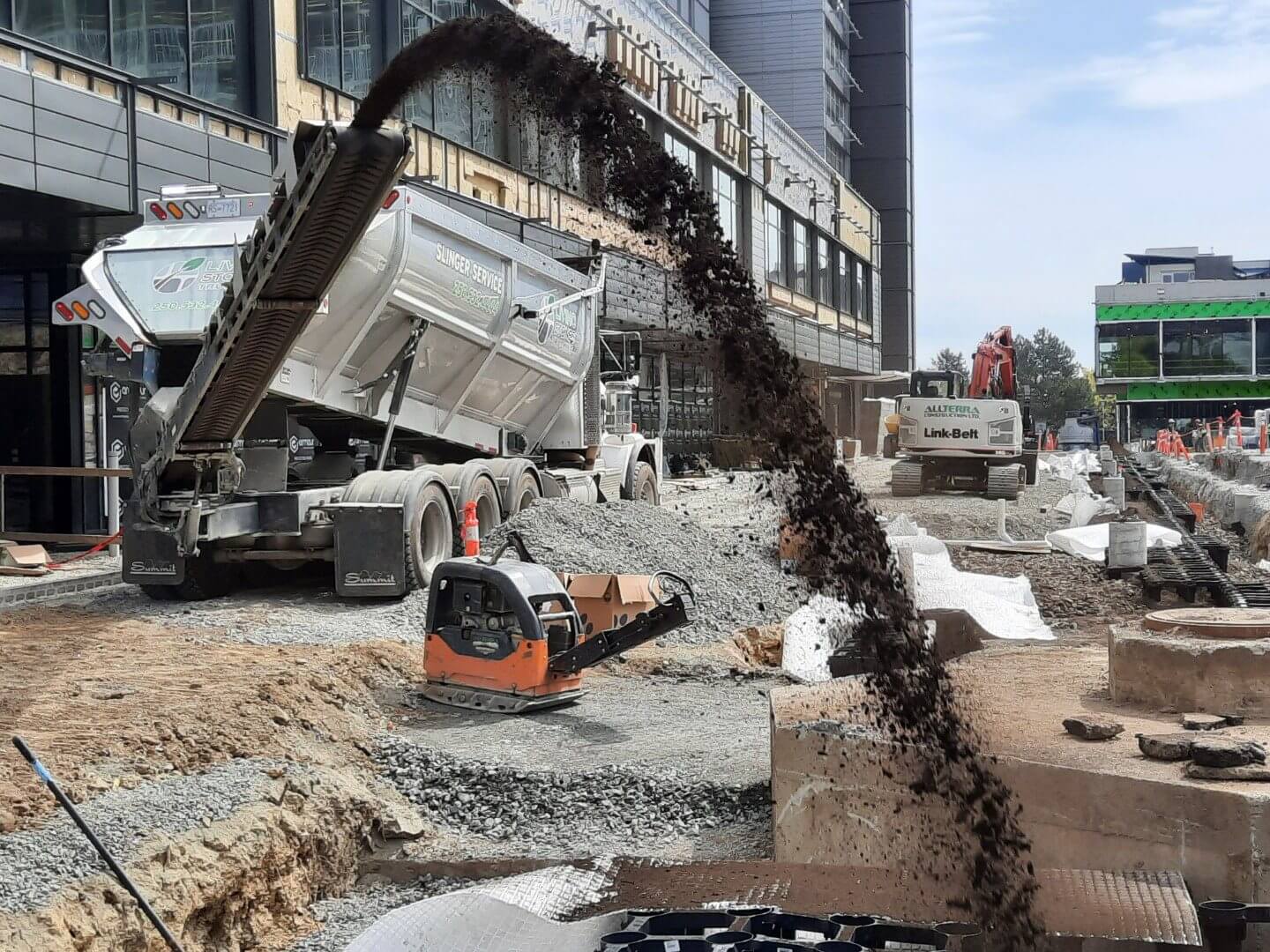 A construction site uses commercial slinger truck shoots dirt into a hole for construction purposes